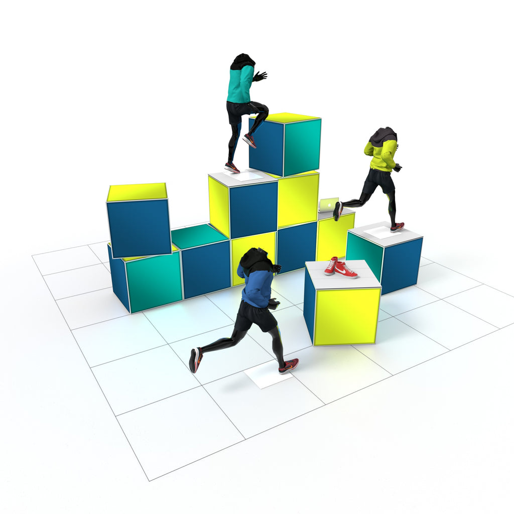 Drei sportliche Schaufensterfiguren in farbenfrohen Outfits erklimmen dynamisch einen Parcours aus leuchtenden Cubes – ein energiegeladener, stilisierter Lauf durch eine urbane Markenwelt. Im Vordergrund präsentieren sich knallrote Sportschuhe auf einem Podest wie ein Pokal für Geschwindigkeit.