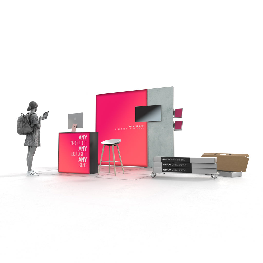Moderner Messestand von Modulap mit auffälliger LED-Lightbox, einer unbeleuchteten Rückwand und einem zentralen Counter. Ein Laptop ist auf dem Counter platziert, während auf der Rückwand ein Fernseher angebracht ist. Eine Person steht links und interagiert mit einem Tablet. Auf der rechten Seite sind mehrere Systemverpackungen und ein Rollbrett zu sehen, die den praktischen Aspekt des Standes unterstreichen. Der Stand vermittelt eine professionelle und einladende Präsentationsumgebung.