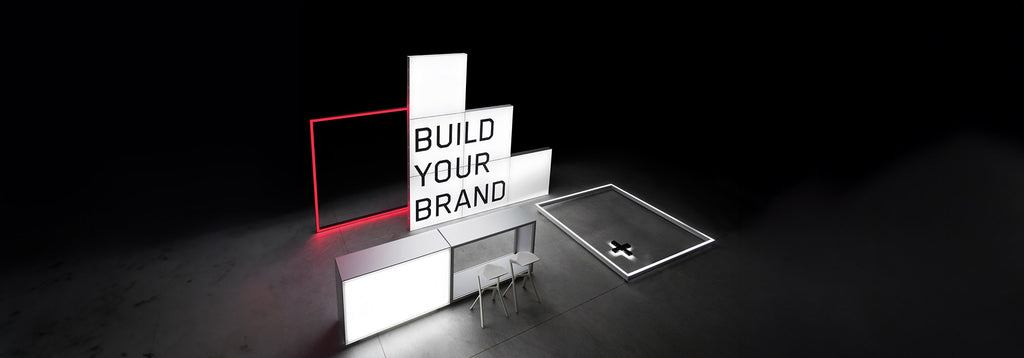 Beleuchteter Messestand mit dem Schriftzug 'Build Your Brand' – Modernes, minimalistisches Design mit leuchtenden Rahmen und modularem Aufbau für Markenpräsentationen.