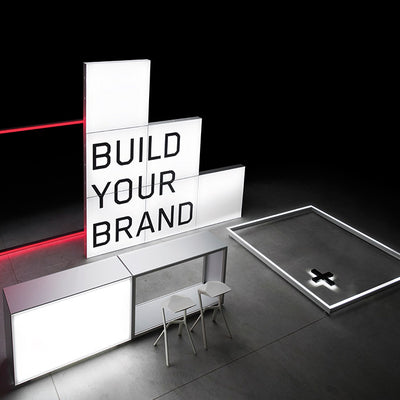 Beleuchteter Messestand mit dem Schriftzug 'Build Your Brand' – Modernes, minimalistisches Design mit leuchtenden Rahmen und modularem Aufbau für Markenpräsentationen.