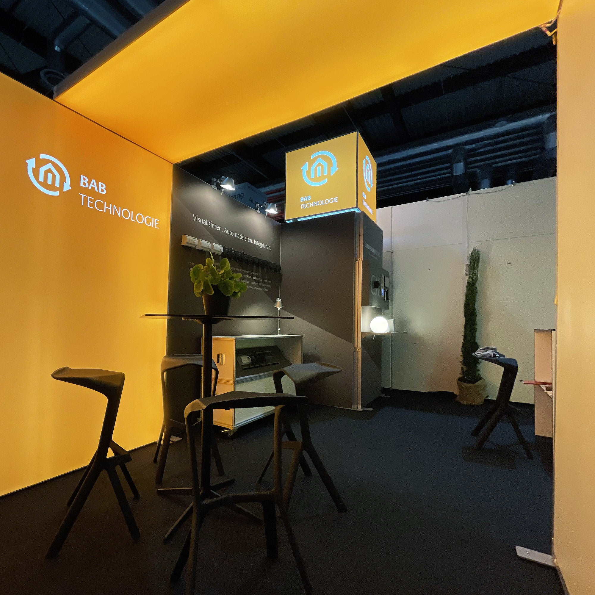 Set Kati mit einer Standfläche von 4x3 m, für schlanke, multimediale Messeauftritte mit optischem Highlight, RGB-Leuchtkontur, Lightbox, Texframe, LED-Counter und flexiblen Transportcases auf einer Messe für BAB Technologie